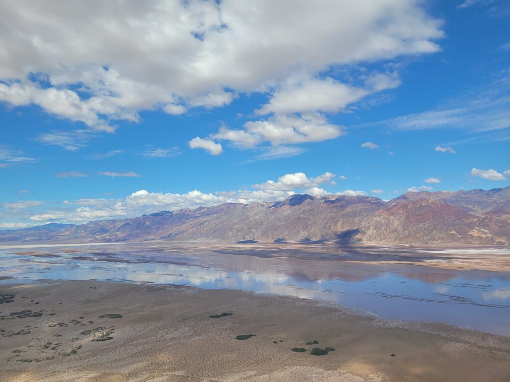 Salt flats and distant mountains under a bright sky in Death Valley